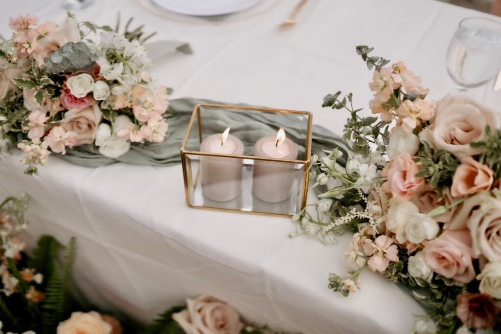 Sweetheart table detail with a gold candle box and florals