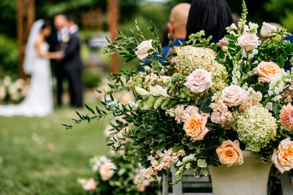 Wedding ceremony with a blush urn arrangement at the altar